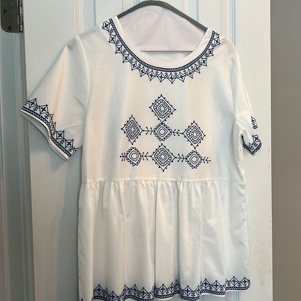 White top with printed navy embellishment.
